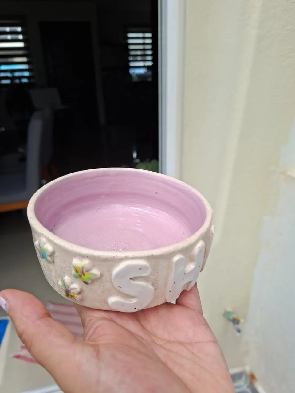 Bowl de cerámica con interior lila, letras y flores en relieve