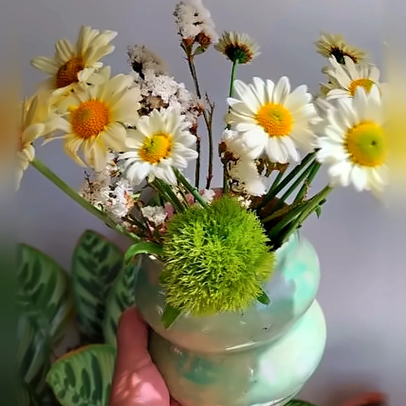 Florero verde ondulado de cerámica con margaritas