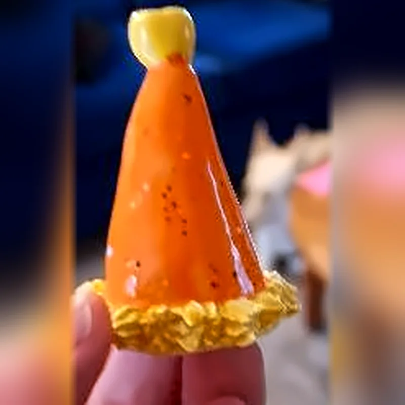 Portavela de cerámica naranja en forma de gorrito de fiesta