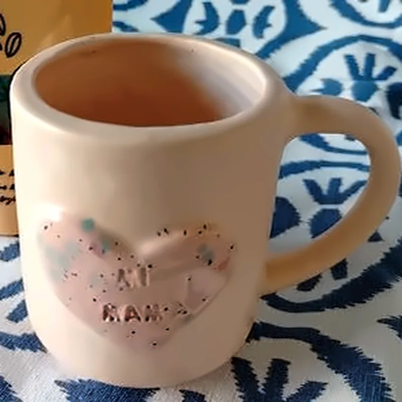 Taza crema de cerámica con un corazón moteado