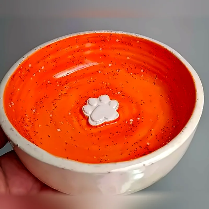 Tazón de cerámica con interior naranja y una huellita